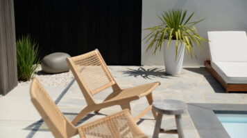 Moderne loungehoek met Brasil White Flagstones rondom een zwembad, gecombineerd met witte ligbedden, houten stoelen en groene planten. De stijl past zeer goed bij een mediterrane uitstraling.