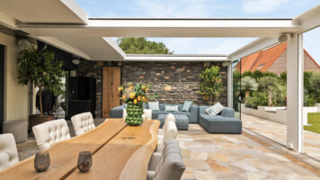 Luxe veranda met een vloer van Flagstones en een wand met Steenstrips.