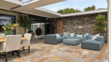 Zomerse veranda met een flagstone terras en een geopietra wand