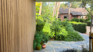 Tuinpad van Blue Plakes Flagstones langs een houten gevel