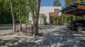 Oprit van Xanti Flagstone XXL bij moderne woning met houten carport