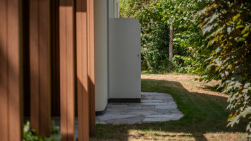 Smal pad van Xanti Flagstone XXL langs houten gevelbekleding