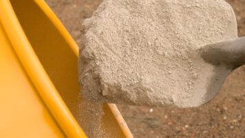 Een schep vol met aangemaakt bindmiddel van ROMFIX uit betonmolen mixer
